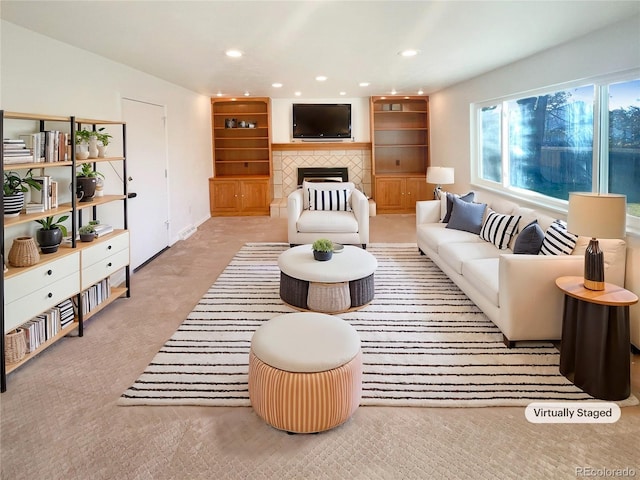 carpeted living area with recessed lighting and a tile fireplace