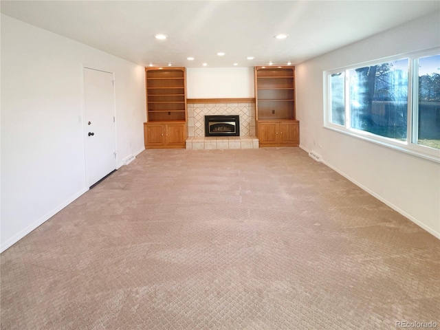 unfurnished living room featuring recessed lighting, a fireplace, baseboards, and light carpet