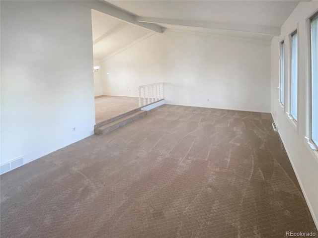 spare room featuring carpet flooring, a healthy amount of sunlight, lofted ceiling with beams, and visible vents