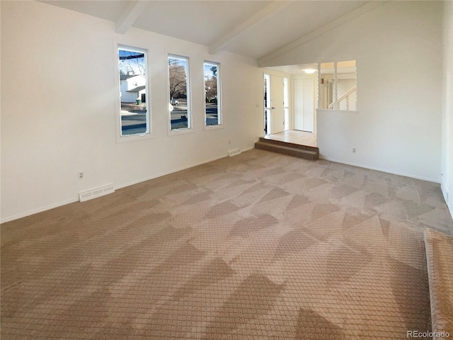 carpeted spare room featuring visible vents, vaulted ceiling with beams, and baseboards