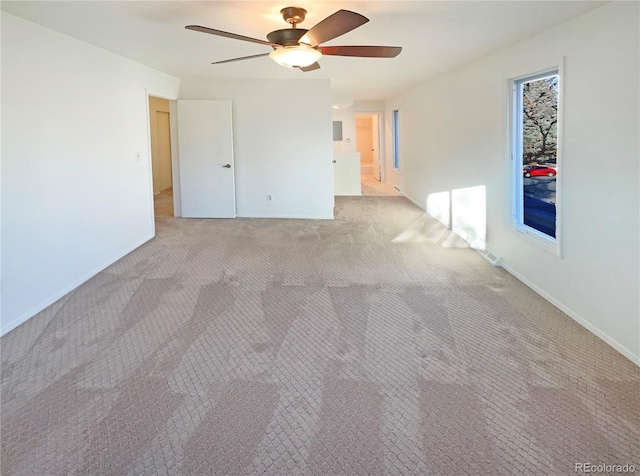 empty room with light carpet, ceiling fan, and baseboards