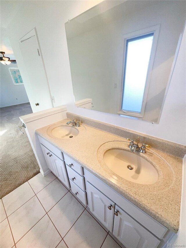 bathroom with double vanity, tile patterned flooring, a healthy amount of sunlight, and a sink