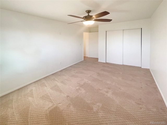 unfurnished bedroom with a closet, baseboards, carpet, and a ceiling fan