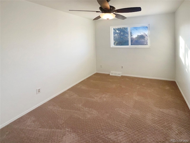 empty room featuring visible vents, carpet floors, baseboards, and ceiling fan