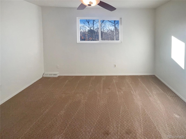 carpeted empty room featuring visible vents, ceiling fan, and baseboards