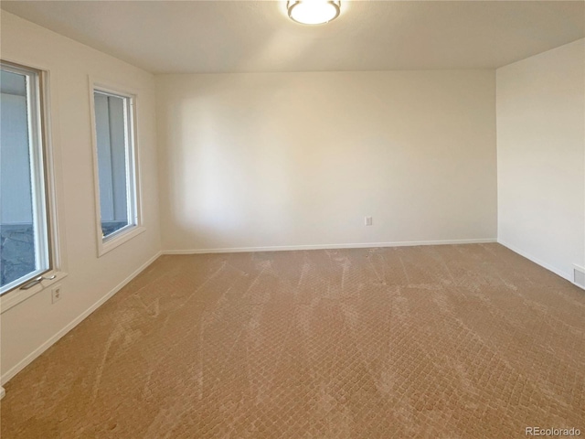 carpeted spare room featuring baseboards