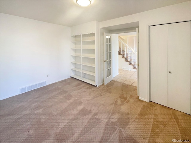 unfurnished bedroom featuring a closet, visible vents, and carpet floors