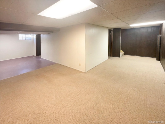 basement featuring carpet and a paneled ceiling