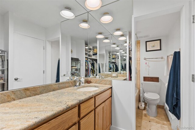 4570 E Yale Ave Unit 1104, Denver, CO 80222 - bathroom featuring vanity, toilet, and a walk in closet