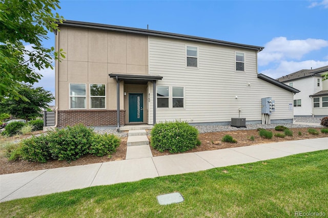 4760 Kittredge St, Denver, CO 80239 - view of front facade with central air condition unit, a front lawn, and brick siding