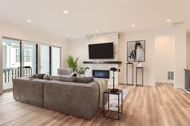 living room with light wood-type flooring and a premium fireplace