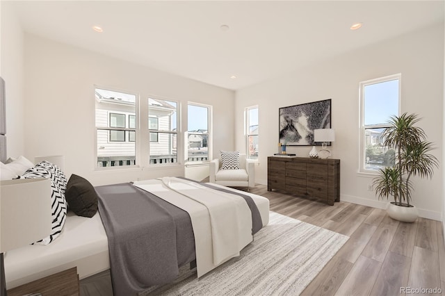 bedroom with light hardwood / wood-style flooring and multiple windows