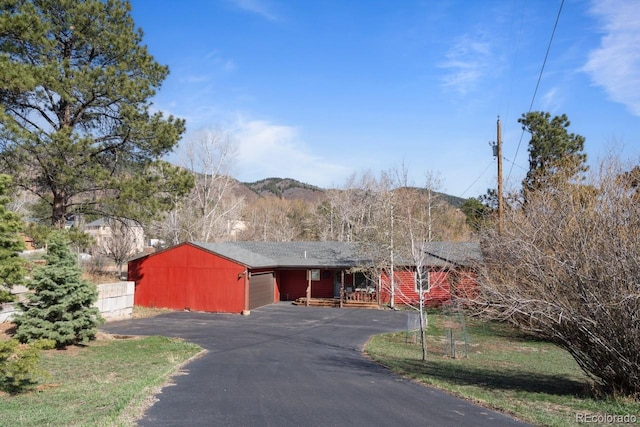 view of front of property featuring an attached garage, driveway, fence, and a mountain view