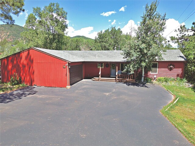 96 Greeley Blvd, Palmer Lake, CO 80133 - rustic home featuring asphalt driveway, an attached garage, and a porch