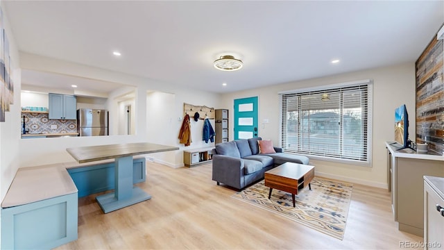 living room featuring recessed lighting, baseboards, and light wood-type flooring