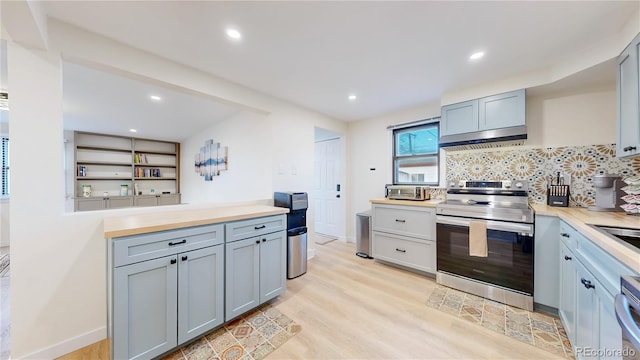 kitchen featuring backsplash, under cabinet range hood, light wood-type flooring, gray cabinets, and stainless steel range with electric stovetop