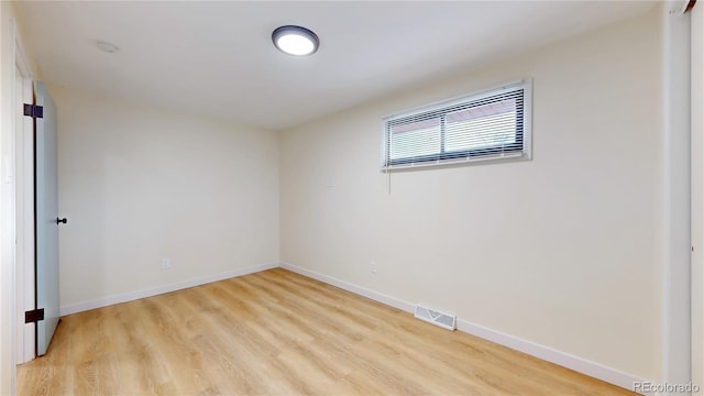 empty room with visible vents, baseboards, and light wood finished floors