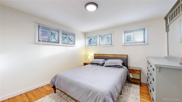 bedroom featuring baseboards and wood finished floors