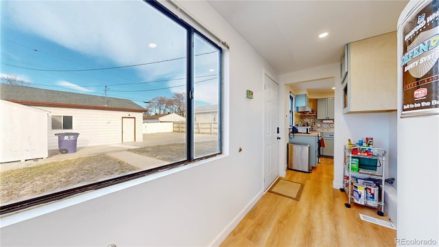 hallway featuring recessed lighting, light wood-type flooring, and baseboards