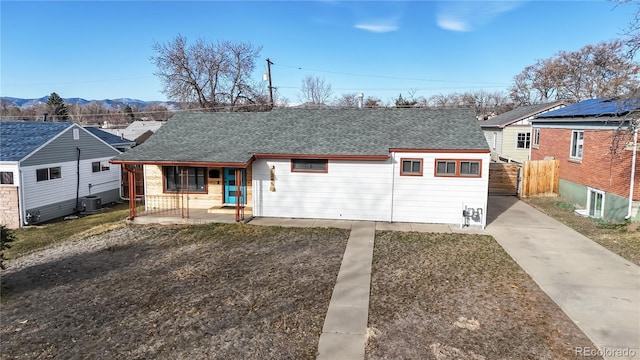 view of front of house with concrete driveway, central AC, roof with shingles, covered porch, and a mountain view