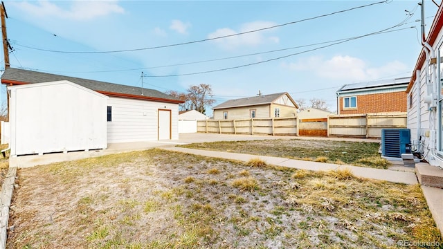 view of yard featuring an outbuilding, central AC unit, and a fenced backyard