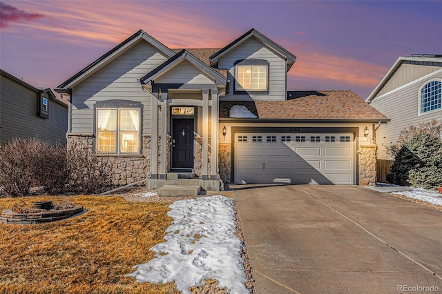 view of front of house featuring stone siding, roof with shingles, an attached garage, and concrete driveway