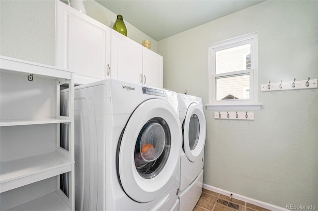 clothes washing area with visible vents, baseboards, cabinet space, and washer and dryer