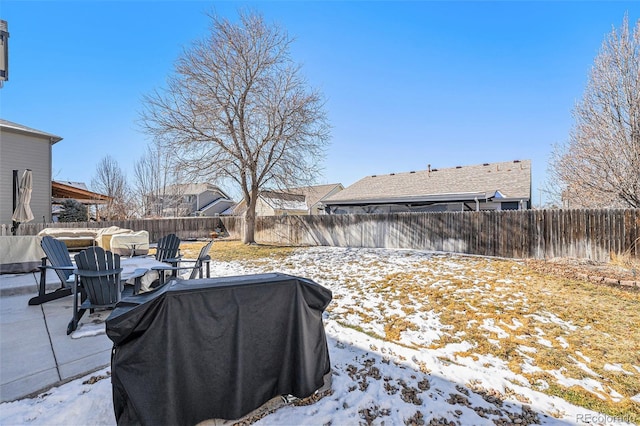 snowy yard with a fenced backyard and a patio