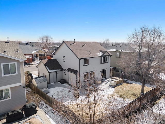 rear view of house with a shingled roof, a fenced backyard, a residential view, a patio area, and stucco siding