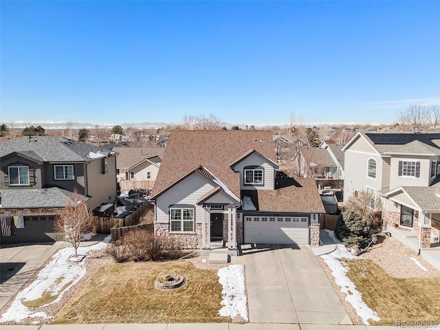 traditional-style house featuring driveway, stone siding, a garage, and a residential view