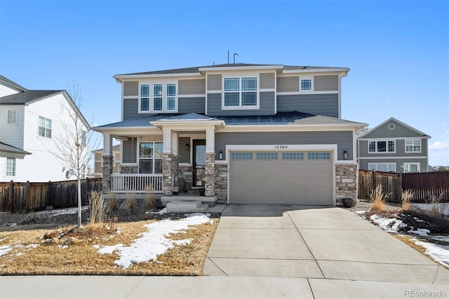 12264 Olive Way, Thornton, CO 80602 - view of front of home featuring covered porch, concrete driveway, a garage, and stone siding