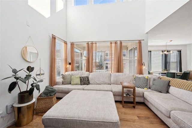 12264 Olive Way, Thornton, CO 80602 - living room featuring a chandelier, a towering ceiling, and light wood-style floors