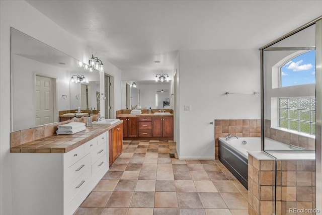 1385 Candleglow St, Castle Rock, CO 80109 - bathroom with double vanity, a garden tub, baseboards, and tile patterned floors