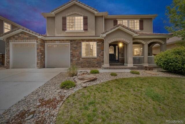 1385 Candleglow St, Castle Rock, CO 80109 - view of front of home featuring a porch, stucco siding, concrete driveway, stone siding, and a lawn