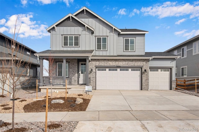 craftsman-style home featuring driveway, a garage, covered porch, fence, and board and batten siding