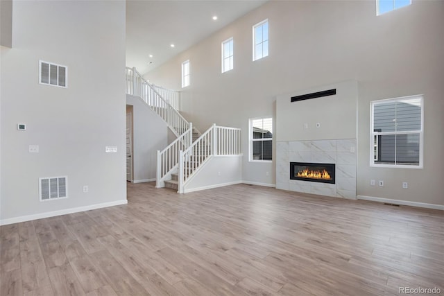 unfurnished living room featuring baseboards, visible vents, and light wood-style floors