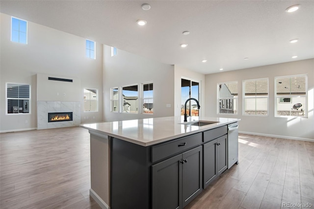 kitchen featuring dishwasher, light wood finished floors, gray cabinets, and a sink