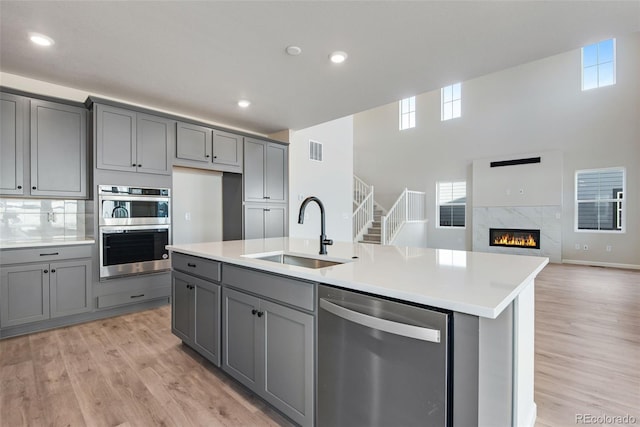 kitchen with appliances with stainless steel finishes, gray cabinets, and a sink