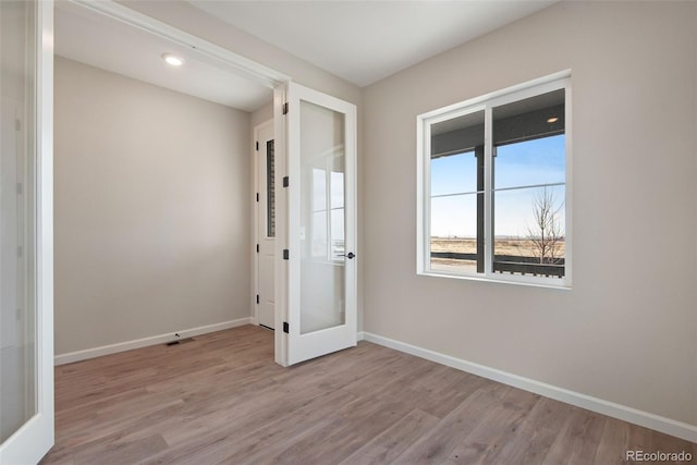 interior space with french doors, visible vents, baseboards, and wood finished floors