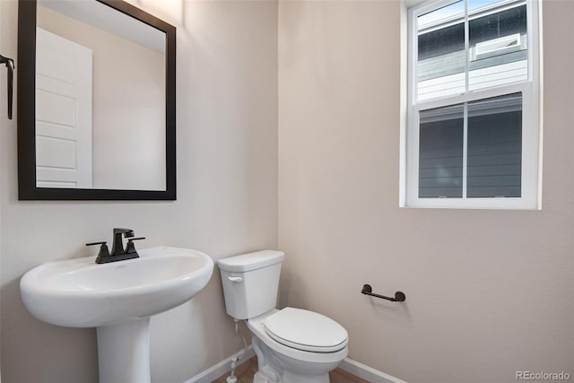 half bathroom with toilet and baseboards