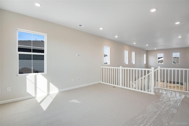 empty room with carpet floors, recessed lighting, a healthy amount of sunlight, and baseboards