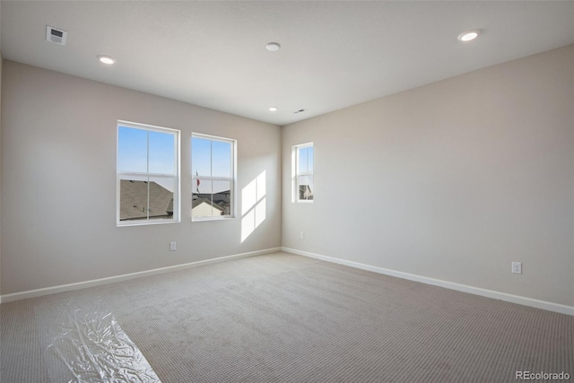 carpeted empty room with recessed lighting, visible vents, and baseboards