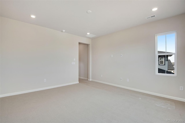 unfurnished room with recessed lighting, light carpet, visible vents, and baseboards