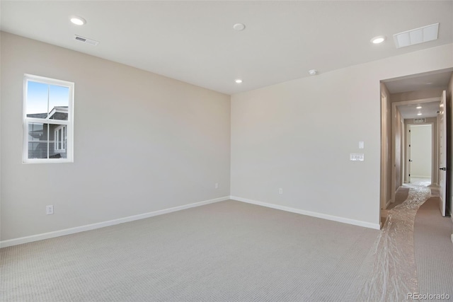 unfurnished room with light carpet, recessed lighting, visible vents, and baseboards