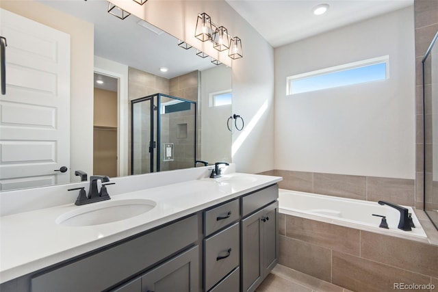 full bathroom with a garden tub, double vanity, a stall shower, and a sink