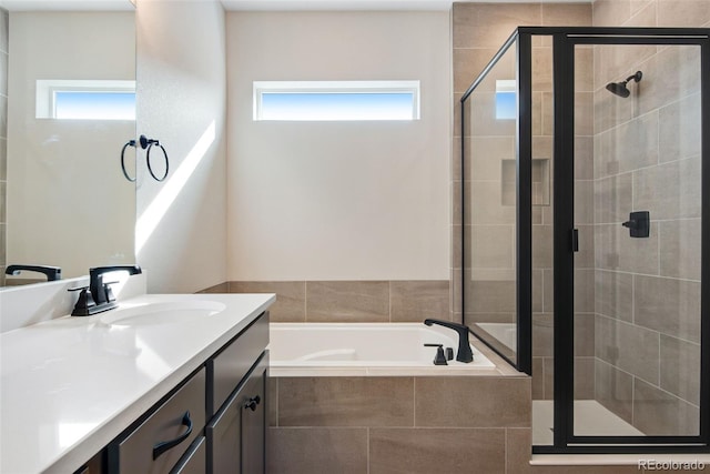 full bathroom featuring a stall shower, vanity, and a bath