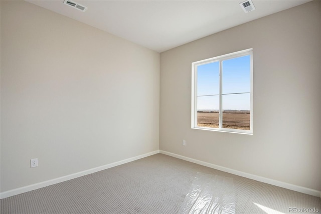 carpeted spare room featuring visible vents and baseboards