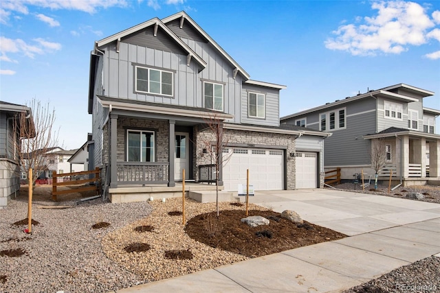 view of front of property with covered porch, stone siding, board and batten siding, and concrete driveway