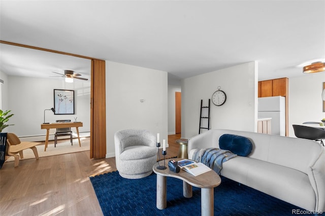 living room featuring ceiling fan, wood-type flooring, and a baseboard heating unit