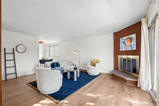 living room featuring wood-type flooring and a brick fireplace